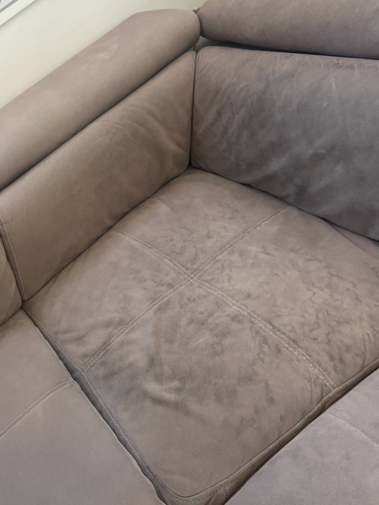 Le même canapé avant nettoyage : assise couverte de taches sombres